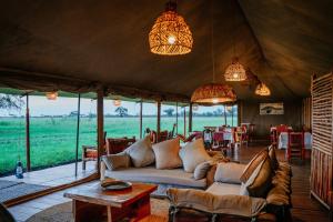 a living room in a safari tent with a couch at Zawadi Serengeti camp in Serengeti National Park