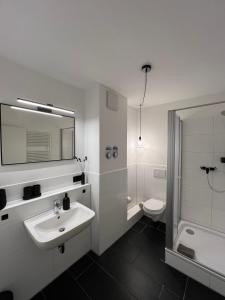 a white bathroom with a sink and a toilet at Studiowohnung 5 in Buxtehude in Buxtehude