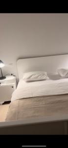 a bedroom with a white bed and a night stand at Antemurale - Luxury rooms,Plitvice Lakes in Rastovača