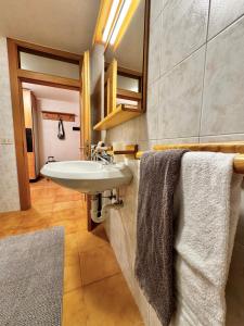 a bathroom with a sink and a mirror and towels at Bait da Diego in Livigno