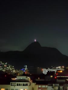 Una luz en la cima de una montaña por la noche en Apartamento Studio completo Copacabana 1 quadra da praia com garagem, en Río de Janeiro