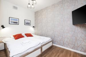 a bedroom with a bed and a flat screen tv at Apartamenty Deo Plaza - Old Town in Gdańsk