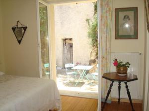 a bedroom with a bed and a door to a patio at La Tonnelle de Vouvray in Vouvray