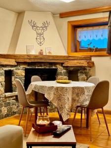 a living room with a table with chairs and a fireplace at Bait da Diego in Livigno