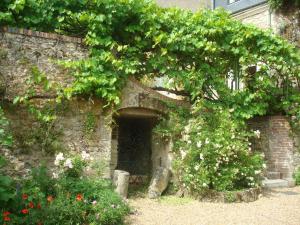 a stone building with a doorway with a bunch of flowers at La Tonnelle de Vouvray in Vouvray