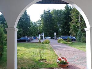 Green House في Wola Przypkowska: ممر مع وعاء من الزهور في حديقة