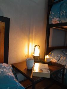 einen Tisch mit einer Kerze, einem Buch und einer Lampe in der Unterkunft Carileufu in Comandante Luis Piedra Buena