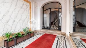 un pasillo con alfombra roja y alfombra roja en Master and kids bdrs separated from rest of the house, en París 2 fotos más