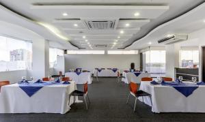 a banquet hall with white tables and chairs at Hotel Vizcaya Plaza in Barrancabermeja