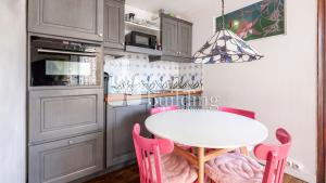 cocina con mesa blanca y sillas rosas en Master and kids bdrs separated from rest of the house, en París