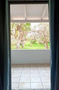 ein offenes Fenster in einem Zimmer mit Fliesenboden in der Unterkunft Lovely Sunrise apartment by the beach in Methoni