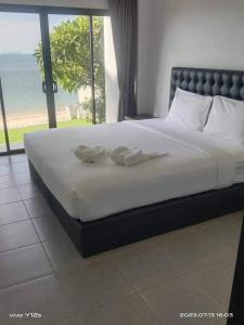 a bedroom with a large bed with a view of the ocean at March Samui Resort in Mae Nam