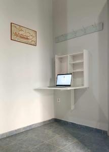 a laptop computer sitting on a shelf in a room at Lovely Sunrise apartment by the beach in Methoni