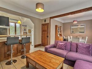 sala de estar con sofá púrpura y mesa en Trois étages de pur Bonheur *Disney*Paris*Jardin* en Champs-Sur-Marne