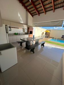 a living room with a table and a kitchen at Casa para temporada Caldas Novas-GO Brasil in Caldas Novas