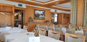 un comedor con mesas y sillas blancas en Berghotel Zollersteighof en Albstadt