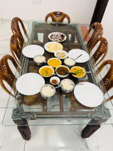 una mesa de cristal con tazones de comida. en Mount court munnar, en Munnar