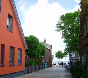 ein orangefarbenes Gebäude an der Straßenseite in der Unterkunft Roter Seestern in Wyk auf Föhr