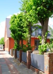 a row of trees in front of a house at Roter Seestern in Wyk auf Föhr