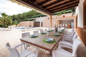 a long wooden table and chairs on a patio at Villa Solaris in Sant Jordi