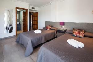 a hotel room with two beds and a mirror at Villa Solaris in Sant Jordi