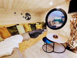 una camera con divano e specchio rotondo di La mini maison dans la prairie a Libin