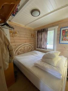 a small bedroom with a bed with a window at Villa Kuuhimon Helmi in Parkano