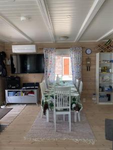 jadalnia ze stołem, krzesłami i telewizorem w obiekcie Villa Kuuhimon Helmi w mieście Parkano