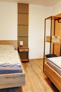 a bedroom with two beds and a wooden floor at Apartment Andreas Bichler in Weistrach