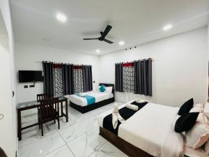 a bedroom with two beds and a desk in it at Mount court munnar in Munnar