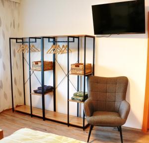 a room with a chair and a shelf with shoes at Apartment Andreas Bichler in Weistrach