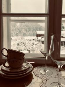 stół z dwoma kieliszkami do wina i oknem w obiekcie BnB44 only rooms no breakfast w mieście Bichlbach