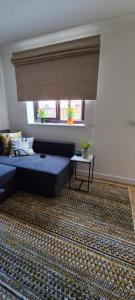 a living room with a blue couch and a window at Lovely 2 bedroom Flat with Free Parking in New Southgate