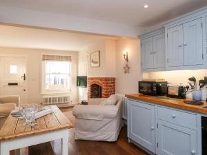 a kitchen with a table and a living room at Shrimpers Cottage, Aldeburgh in Aldeburgh
