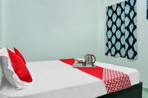 Zimmer mit einem Bett mit roten und weißen Kissen in der Unterkunft Flagship Hotel Tulsi Inn in Dānāpur