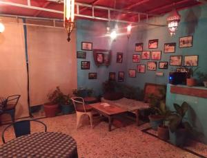um quarto com uma mesa e cadeiras e fotografias na parede em Karma homestay em Jodhpur