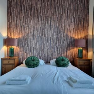 ein Bett mit zwei grünen Kissen darüber in der Unterkunft Apartment Vlissingen Aan Zee in Vlissingen