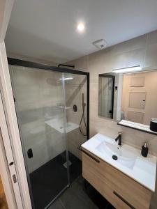 een badkamer met een glazen douche en een wastafel bij Apartamento Cervantes céntrico con garaje in Gijón