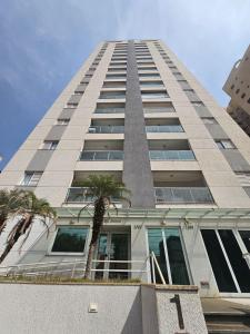 a tall building with palm trees in front of it at Edíficio Sienna in Ribeirão Preto