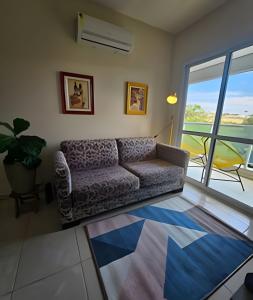 a living room with a couch and a balcony at Edíficio Sienna in Ribeirão Preto