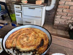 a pie in a pan on a table in a kitchen at Vikendica Pantic in Bijeljina