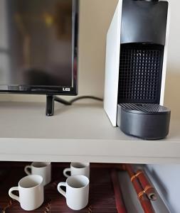 a shelf with a microwave and coffee cups on it at Edíficio Sienna in Ribeirão Preto
