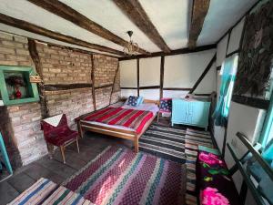 ein Schlafzimmer mit einem Bett und einem Stuhl in einem Zimmer in der Unterkunft Vikendica Pantic in Bijeljina