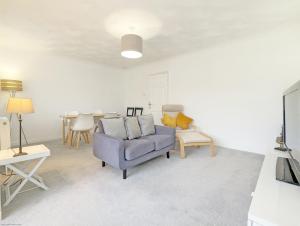 a living room with a blue couch and a table at Marine Lodge in Bognor Regis