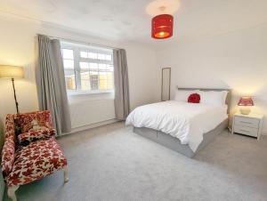 a bedroom with a bed and a chair and a window at Marine Lodge in Bognor Regis