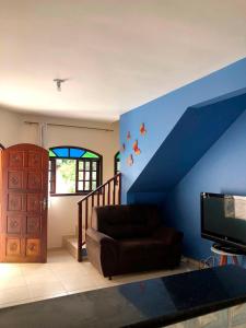 sala de estar con sofá y pared azul en Casa em Ubatuba - Perequê-Mirim, en Ubatuba