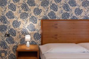 una camera da letto con un letto con carta da parati blu e bianca di Hotel Riva Etrusca a Marina di Bibbona