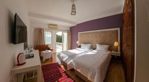 a bedroom with a large bed and purple walls at Hôtel L'Hacienda in Rabat