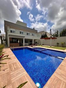 a large blue swimming pool in front of a house at NoMar in Guarujá