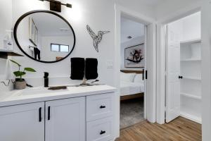Baño blanco con espejo y lavabo en Artsy - A Birdy Vacation Rental, en San Antonio